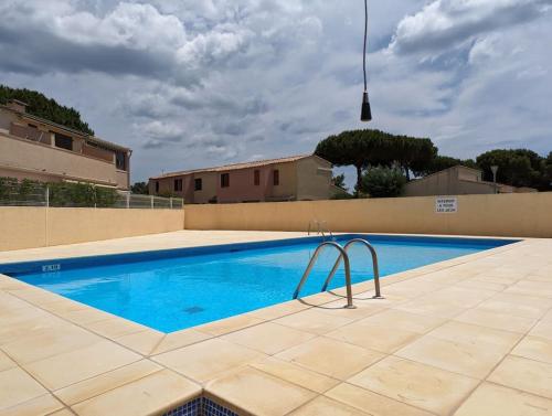 une piscine au milieu d'une maison dans l'établissement Rez-de-jardin Pinède Piscine Clim proche Plage Village naturiste, au Cap d'Agde