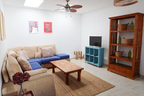 salon z niebieską kanapą i telewizorem w obiekcie Casitas Tenerife - El Risco 2 w mieście Los Cristianos