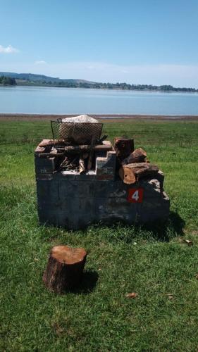 an old stove sitting in the grass next to a lake at Isikhoma-Khoma in Hilton