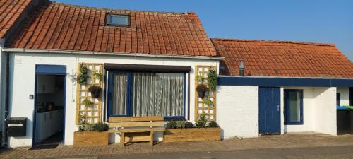 a small house with a bench in front of it at Schrijvershuisje - sfeer & stilte Zeeuws Vlaanderen in Zaamslag