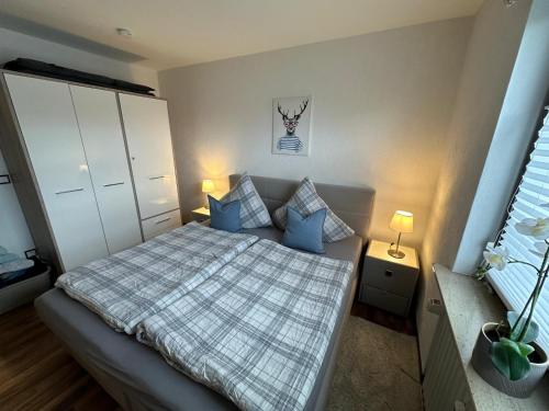 een kleine slaapkamer met een bed met blauwe kussens bij Ferienwohnung Winterberg Centrum 2 mit privatem Ski Keller in Winterberg