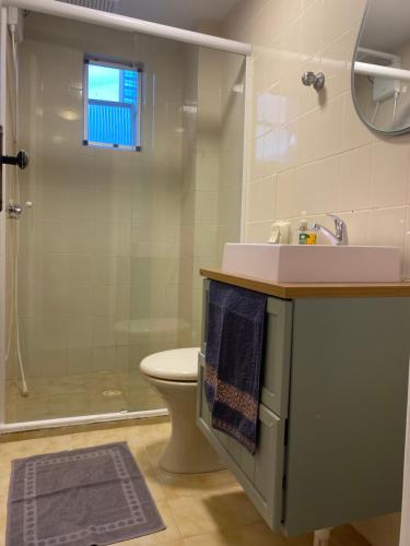 a bathroom with a sink and a toilet and a shower at Apto a 50m da praia in Balneário Camboriú