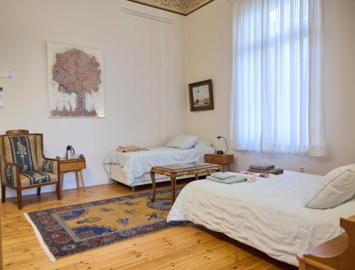 a living room with two beds and a chair at 1906 Citygarden in Chios