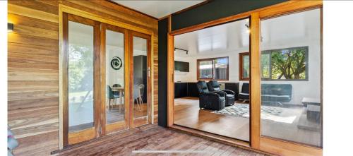 a room with glass doors and a living room at 2 Bedroom Cottage with Lagoon pool & spa in Capalaba