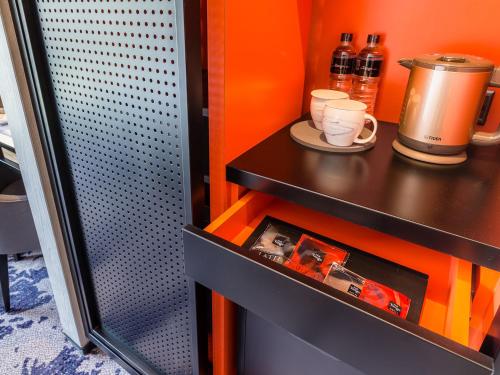 a black and orange cabinet with a coffee cup at Tango Inn Taipei Jihe in Taipei