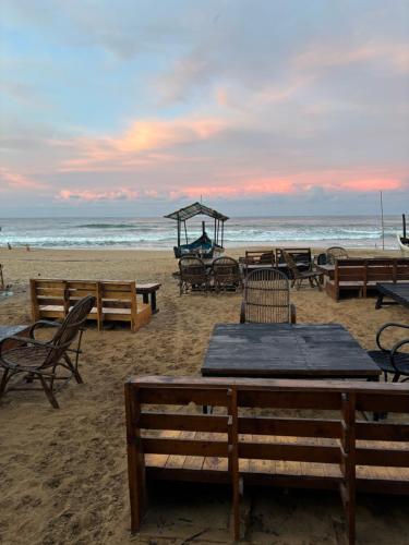a group of tables and chairs on the beach at Drishti yoga international in Patnem