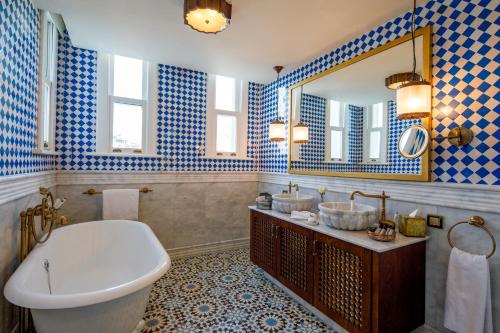 a bathroom with a tub and a sink and a mirror at Hagia Sofia Mansions Istanbul, Curio Collection by Hilton in Istanbul
