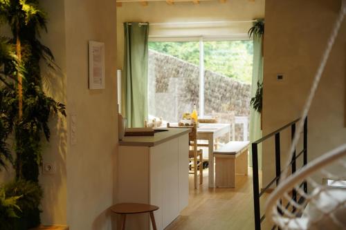 une cuisine et une salle à manger avec une table et une fenêtre dans l'établissement Maison atypique Alsace - Là Haut, à Lautenbach