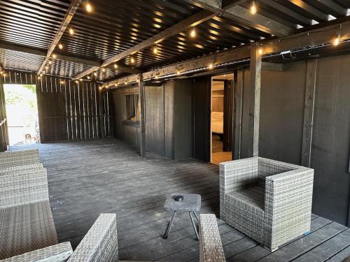 a patio with chairs and a table and lights at TheWaterfrontLodges in Coventry