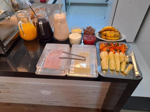 a table with a tray of food and some drinks at Hospedagem Jardins de Gramado in Gramado