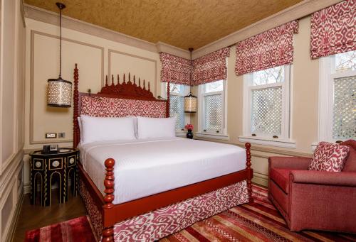 a bedroom with a bed and a red chair at Hagia Sofia Mansions Istanbul, Curio Collection by Hilton in Istanbul