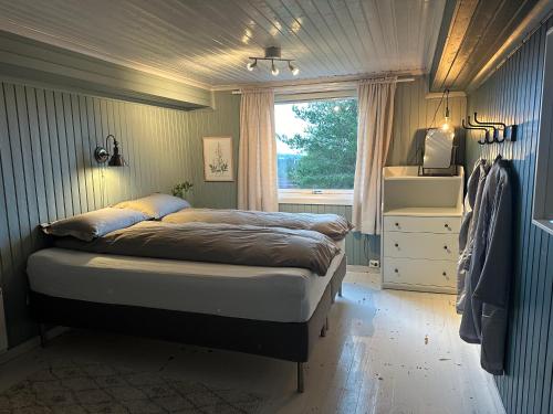 una camera da letto con un letto grande con una finestra di Guesthouse 20 min from Sjusjoen, 30 min from Lillehammer and Hamar, 2h from Oslo a Ringsaker