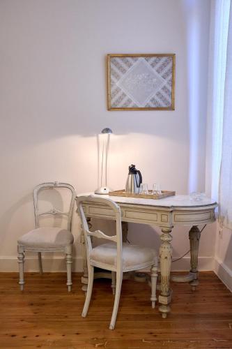 a desk with two chairs and a table with a lamp at 1906 Citygarden in Chios