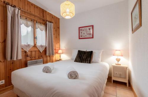 een slaapkamer met een groot wit bed in een kamer bij Les Carlines in Les Contamines-Montjoie