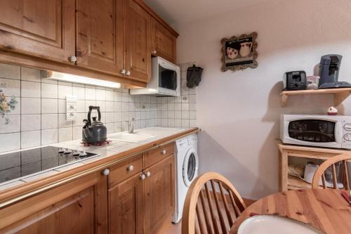une cuisine avec un lave-linge et un micro-ondes dans l'établissement Les Carlines, aux Contamines-Montjoie
