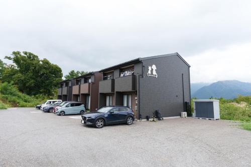 a building with cars parked in a parking lot at Habitacion Cottage Suzu in Fujikawaguchiko