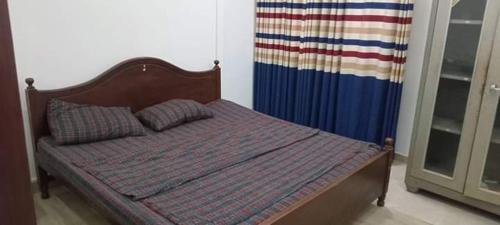 a bed in a bedroom with an american flag curtain at Rohan's Residence in Kandana