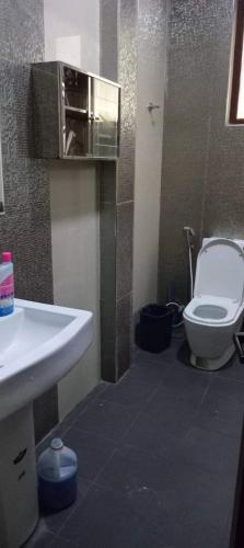 a bathroom with a white toilet and a sink at Rohan's Residence in Kandana