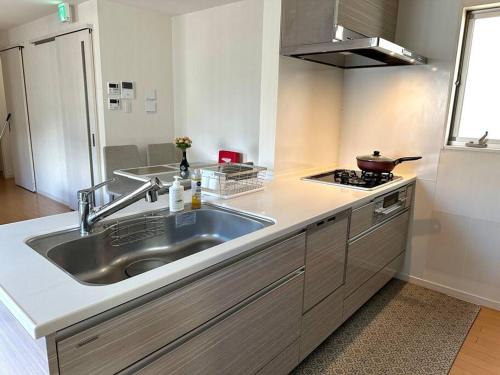 a kitchen with a sink and a stove at DeL'm 難波から徒歩圏内京都奈良universal studio 関西空港まで交通便利無料駐車場付き in Osaka