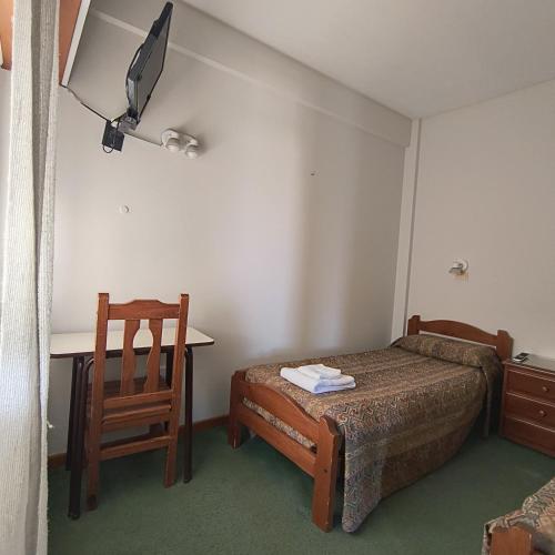 a bedroom with a bed and a desk and a chair at Hotel Peumayen in Viedma