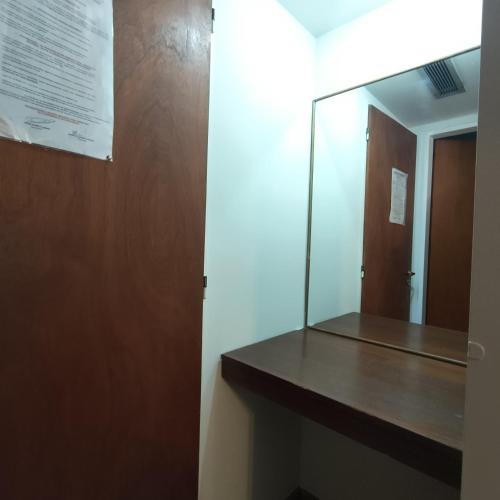 a mirror in a bathroom with a wooden counter at Hotel Peumayen in Viedma