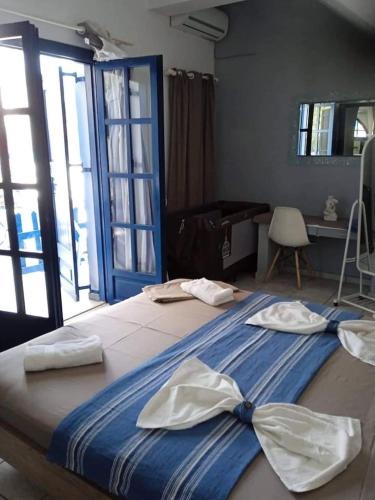 a large bed with a blue blanket with a bow on it at Erofili Apartment in Kalyves