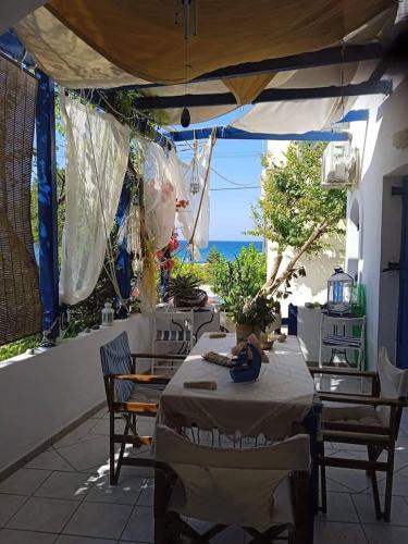 a patio with a table and chairs and the ocean at Erofili Apartment in Kalyves