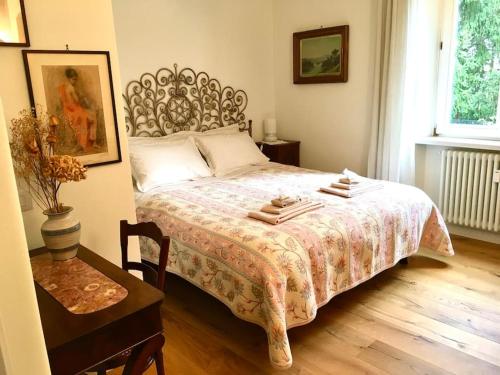 a bedroom with a bed and a table with a chair at Dodici Lune Apartment in Rovereto