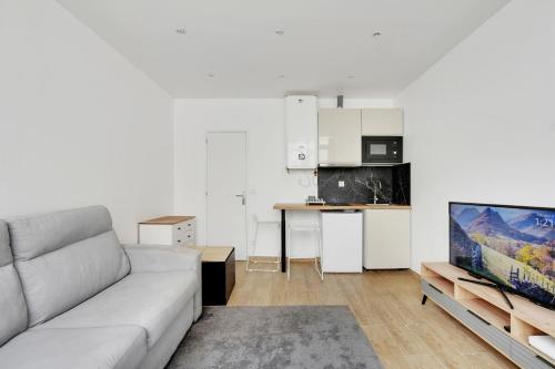 un salon avec un canapé et une cuisine dans l'établissement Studio lumineux au centre de Vincennes, à Vincennes