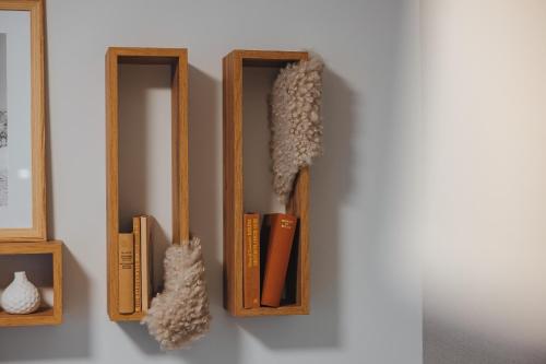 two wooden bookshelves on a wall with books at Goldhorn Chalet SKI IN&OUT in Kranjska Gora