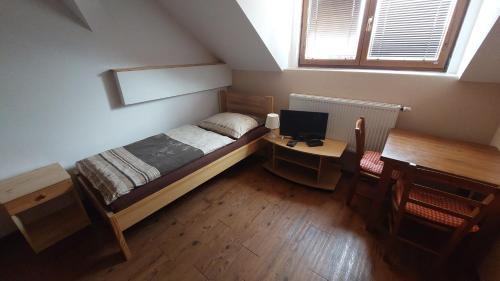 a bedroom with a bed and a desk with a computer at Penzion Staré Sedlo in Bor