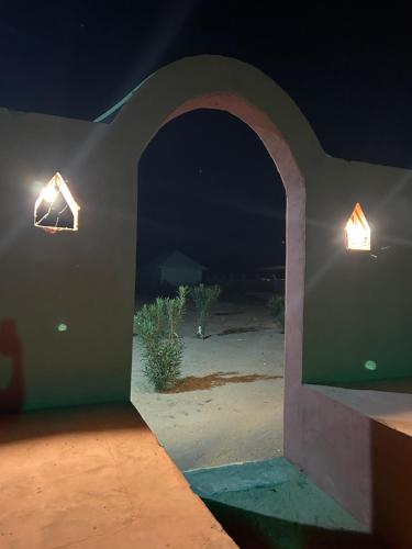 a room with two lights on a wall at night at Sunny Desert Camp in Kūri