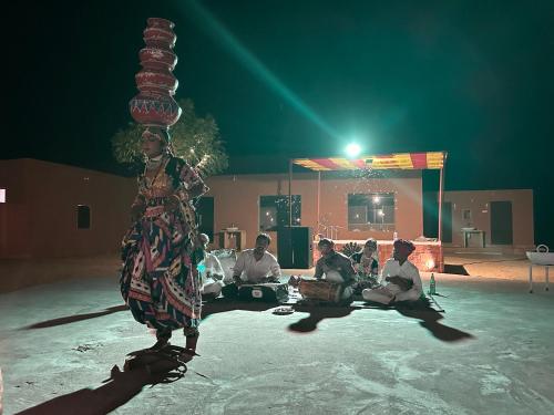 a woman is standing on a stage with a stack at Sunny Desert Camp in Kūri