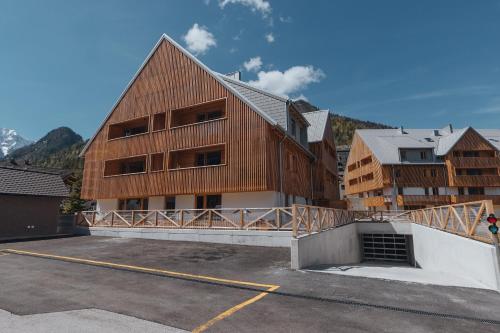 a large wooden building in a parking lot at Goldhorn Chalet SKI IN&OUT in Kranjska Gora