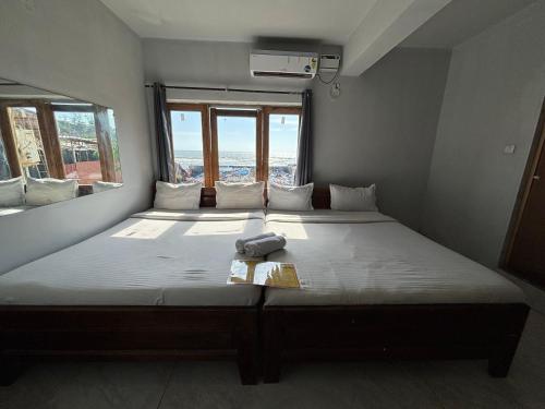 a large bed in a room with a large window at Baga Beach Sunset in Baga