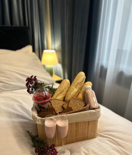 a basket of bread and drinks on a bed at Richmount Apartamenty Karpacz in Karpacz