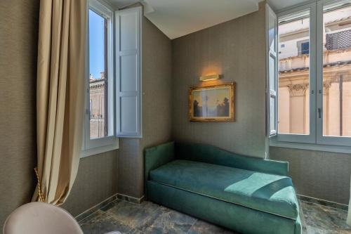 a green couch in a room with windows at Piazza di Spagna 51 Luxury guest house in Rome
