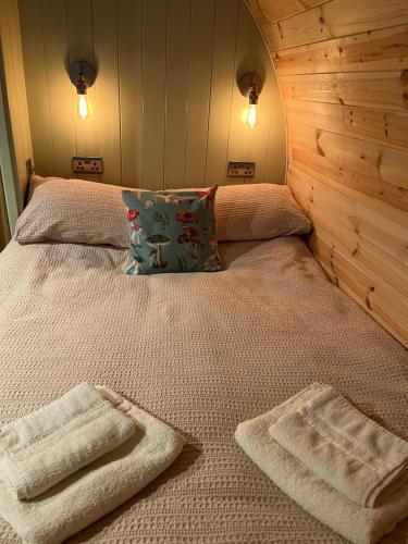 a bed with two towels on top of it at Mushroom Pod in Gloucestershire