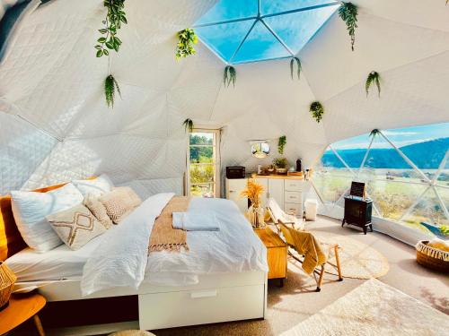 a bedroom with a bed in a tent at Glamping Hohe Wand - Kuppelzelt mit Whirlpool & Panoramafenster in Maiersdorf