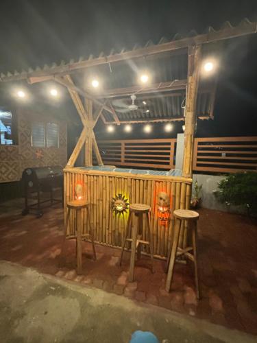 a patio with two stools and a table and a grill at blue starfish villa in Panglao