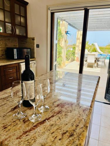 a bottle of wine sitting on a counter with wine glasses at Villa Amandine in Peyia