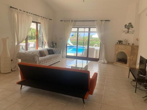 a living room with a couch and a fireplace at Villa Amandine in Peyia