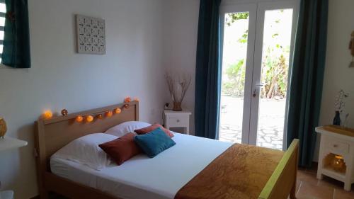 a bedroom with a bed with two pillows on it at Chambre indépendante donnant sur piscine in Le Marin