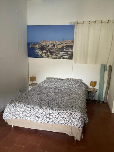 une chambre avec un lit avec un tableau sur le mur dans l'établissement Sur le port face à la citadelle, à Bonifacio