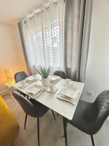 a white dining table with chairs and a window at Cosy Modern Flat with garden in Longbridge