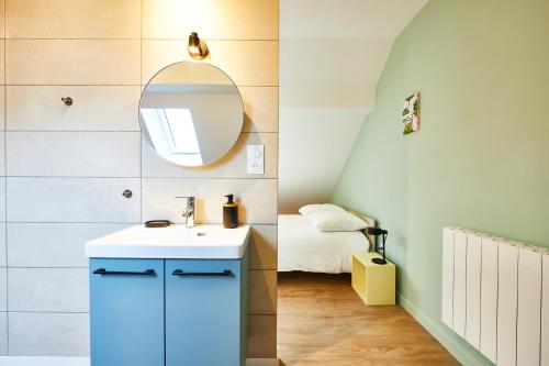 La salle de bains est pourvue d'une armoire bleue et d'un miroir. dans l'établissement RB-3 Charmant appartement 2 pers dans les combles 3ème étage, à Mulhouse