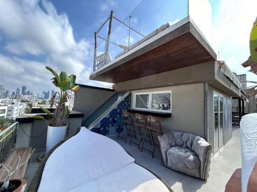 a balcony with chairs and a table on a roof at Luxury apartment Tel Aviv Gordon Beach Ha Yarkon in Tel Aviv