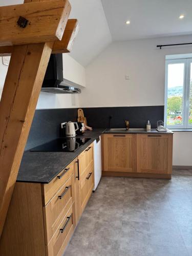 une cuisine avec des placards en bois et une grande fenêtre dans l'établissement Le 