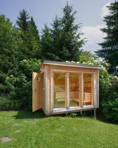 a wooden shed in the grass in a yard at Villa Ruah in Weissensee