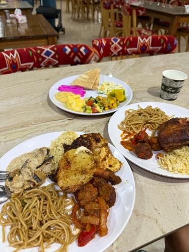 Una mesa con tres platos de comida encima. en Wadi Rum Lana luxury camp, en Wadi Rum